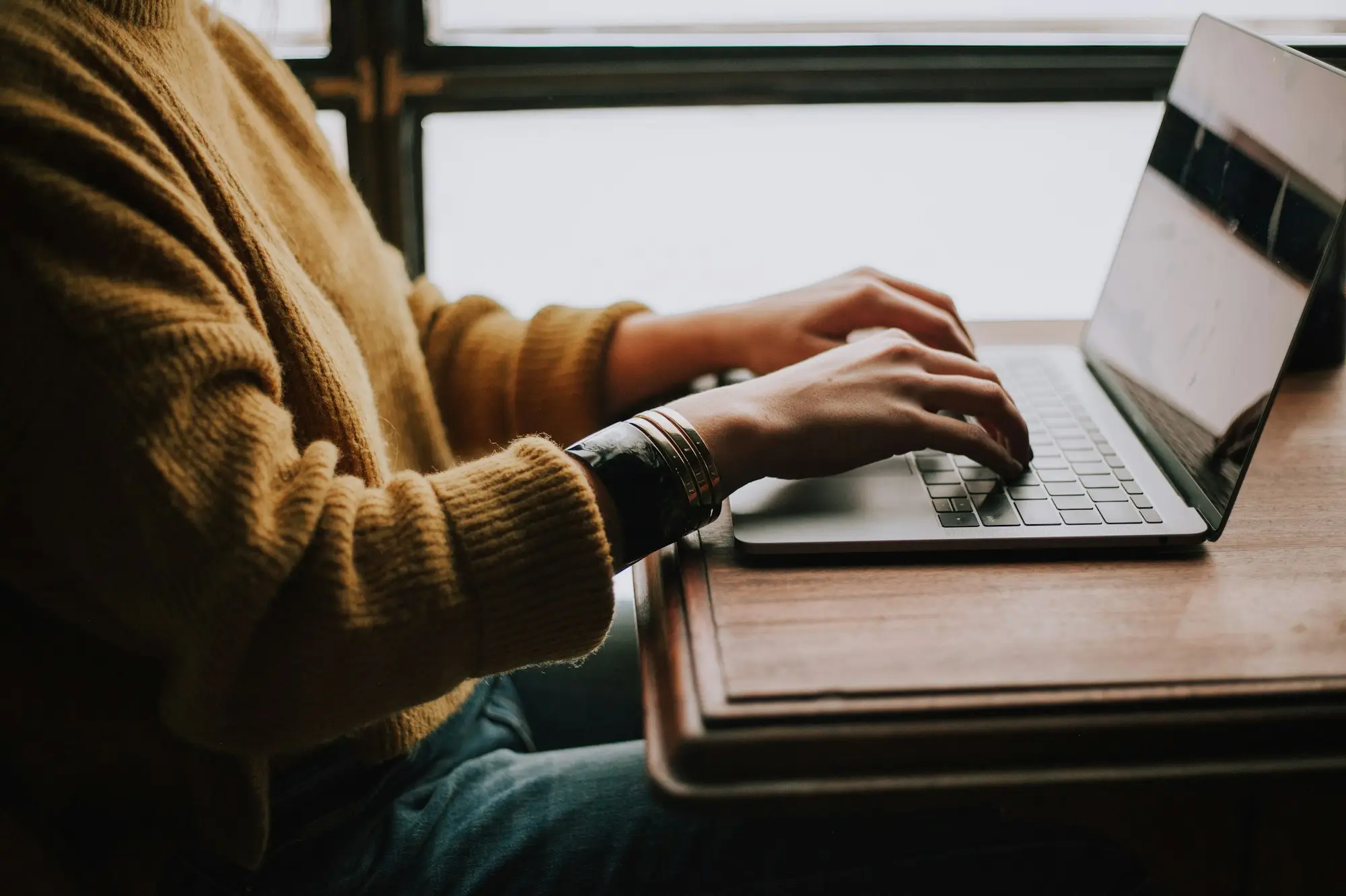 Home office desk with laptop open on a banking-style transaction list