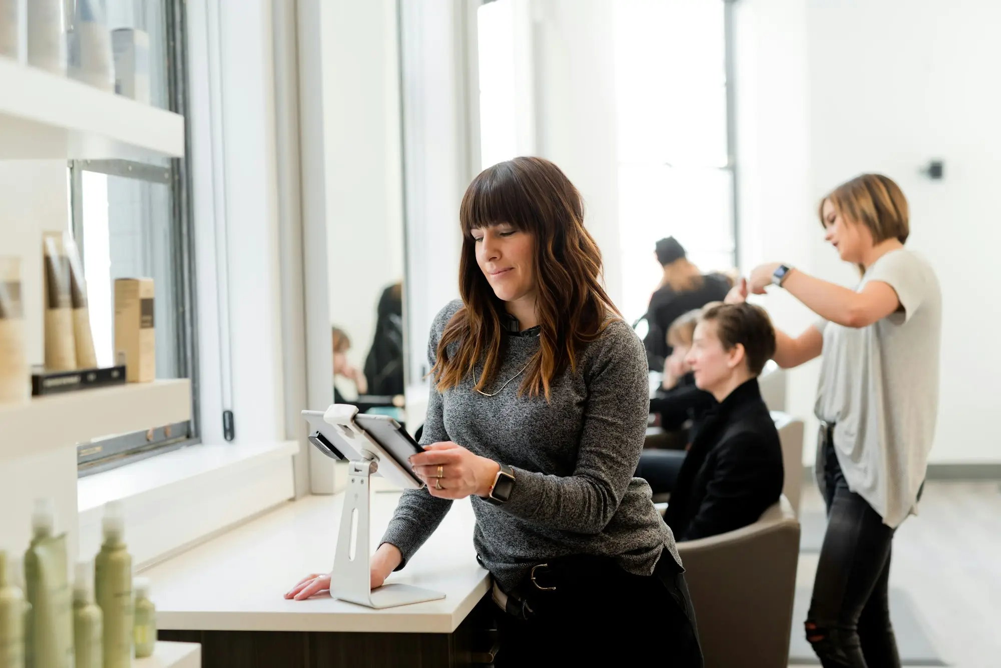 Hair salon front counter with owner using a tablet POS