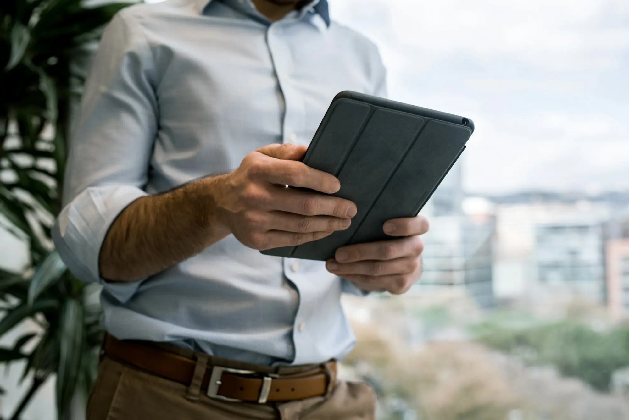 Owner in a studio workspace looking at line charts on a tablet