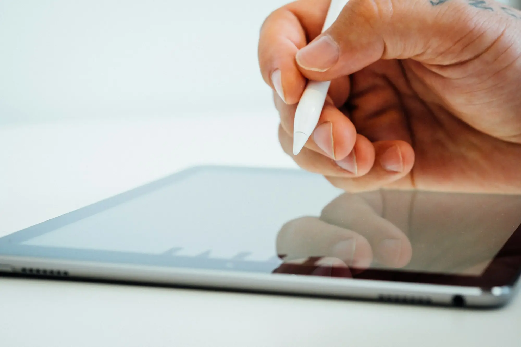 Owner of a small business signing on a tablet with a stylus at a workbench or office desk