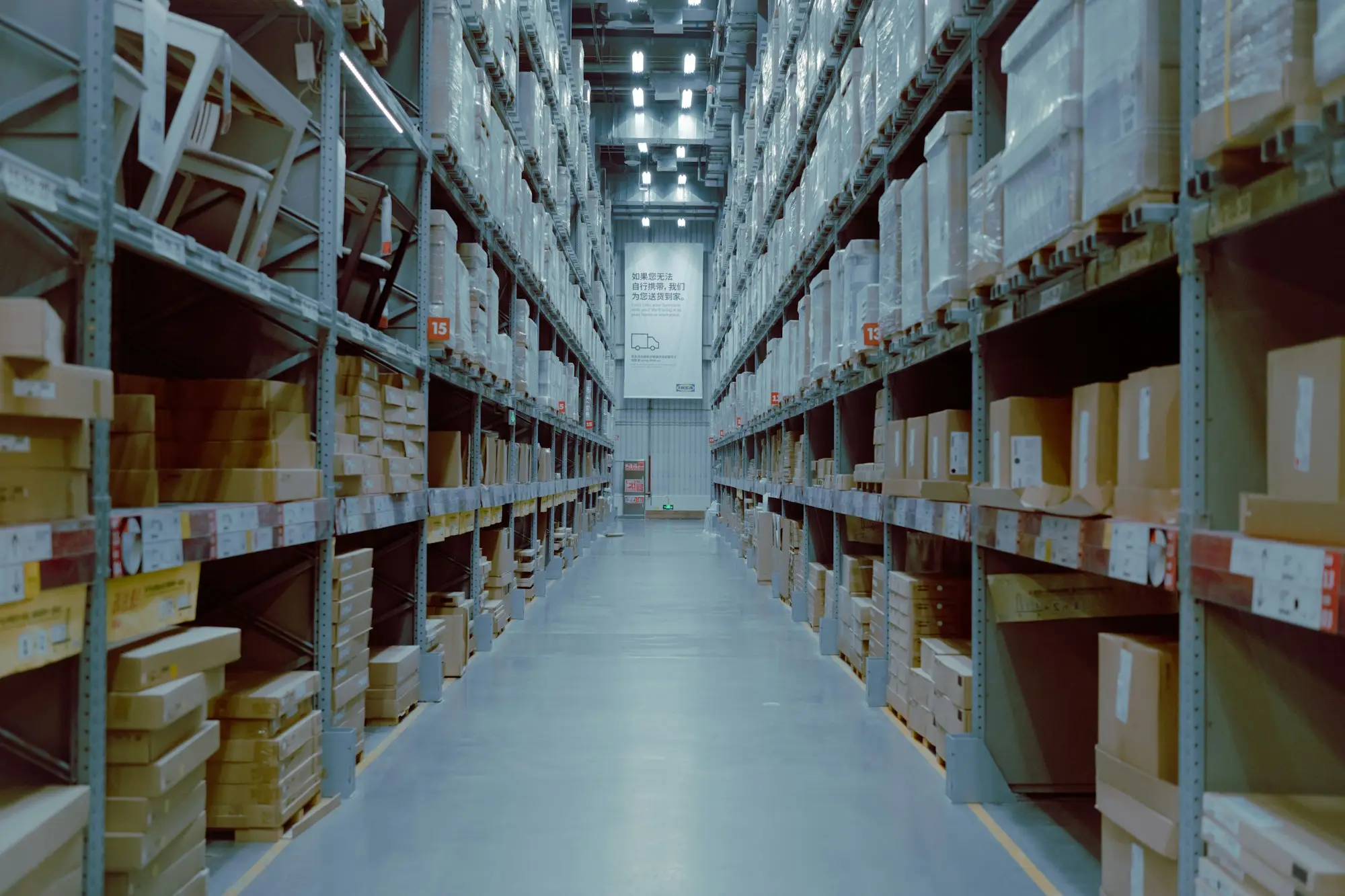 Racking with labelled boxes of inventory in a small warehouse